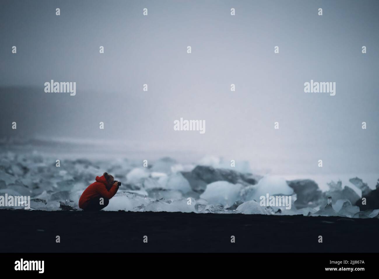 Icebergs over the black sand beach with tourist, winter day Stock Photo