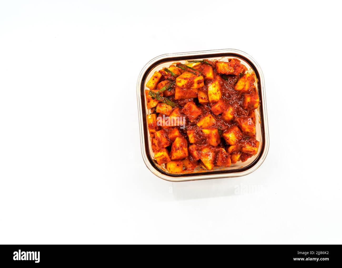 Top view Radish Kimchi in a brown-glass container, rectangle shape. Isolated Korean healthy food or Kimchi on white background. Flat lay image of Radi Stock Photo