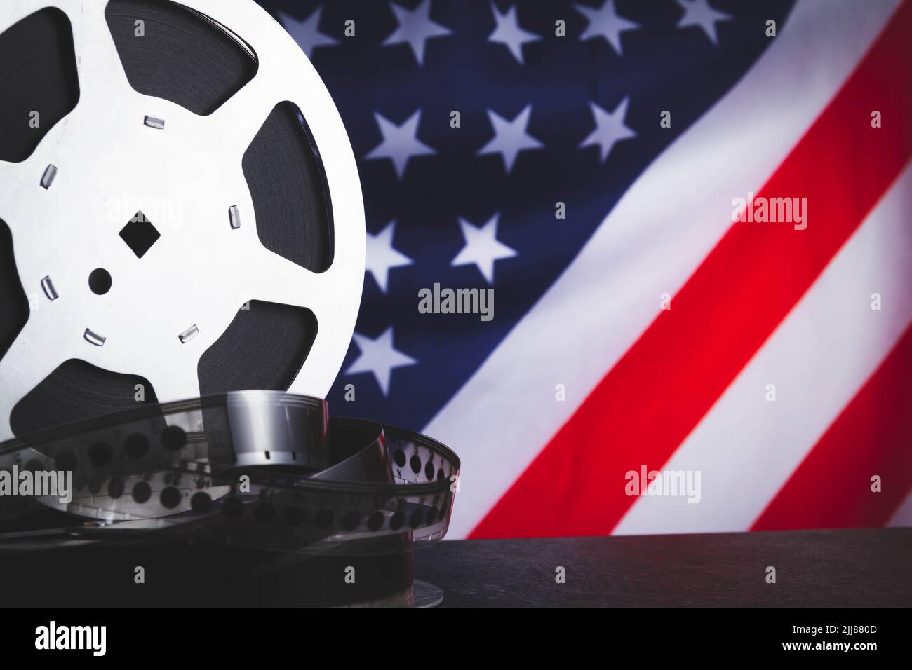 American cinema. Cinematography in the USA. Old film reel on the background of the flag of America. Stock Photo