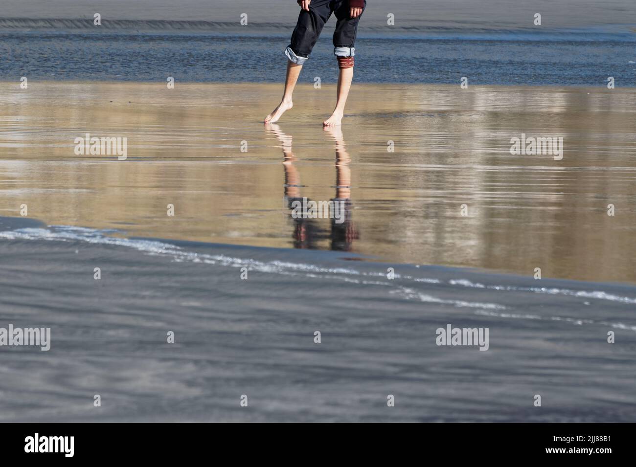 A summer's day invites rolled up jeans and getting your feet wet at the beach. Stock Photo