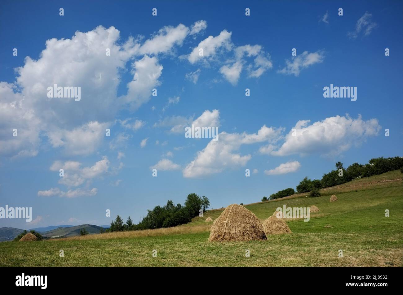 clouds sky on haystacks in a meadow of Serbia Stock Photo