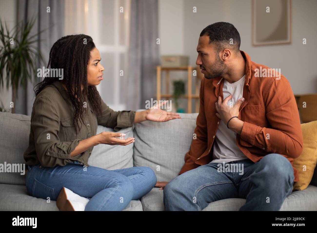 Angry Black Couple Having Quarrel Sitting On Sofa At Home Stock Photo ...