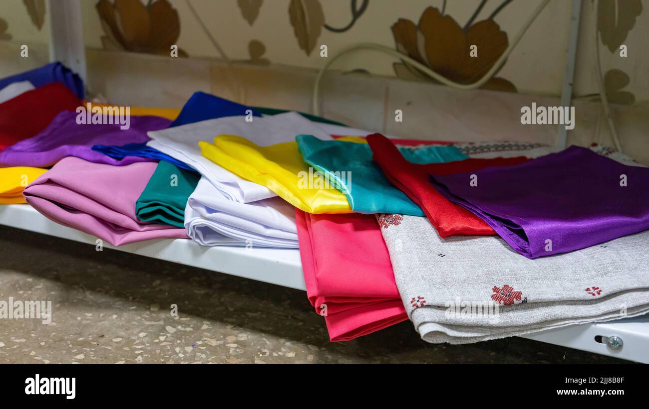 Multicolored kitchen towels lie folded on a shelf. Stock Photo