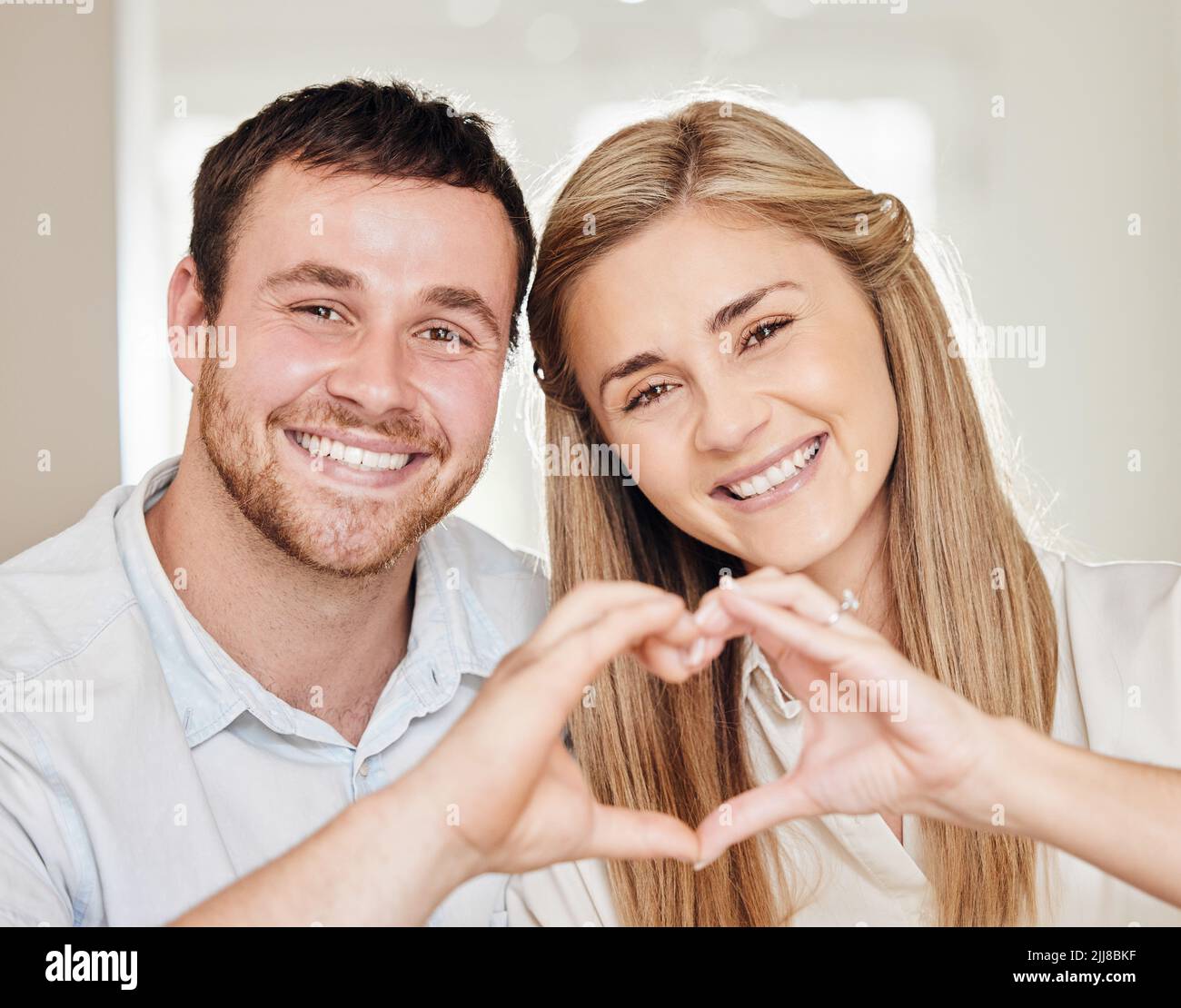 They are Gods gift to you. a young couple making a heart sign with their hands at home. Stock Photo