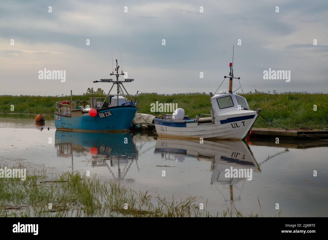 Boats moored on a tidal creek Stock Photo