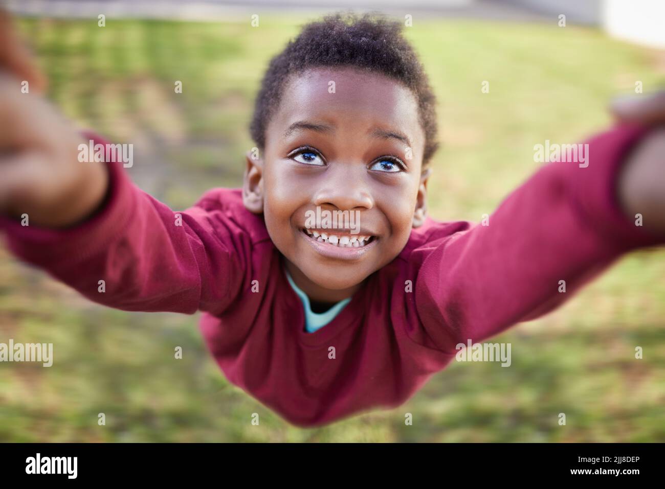 The crazy, carefree days of youth. an adorable little boy being swung by his hands in a garden. Stock Photo