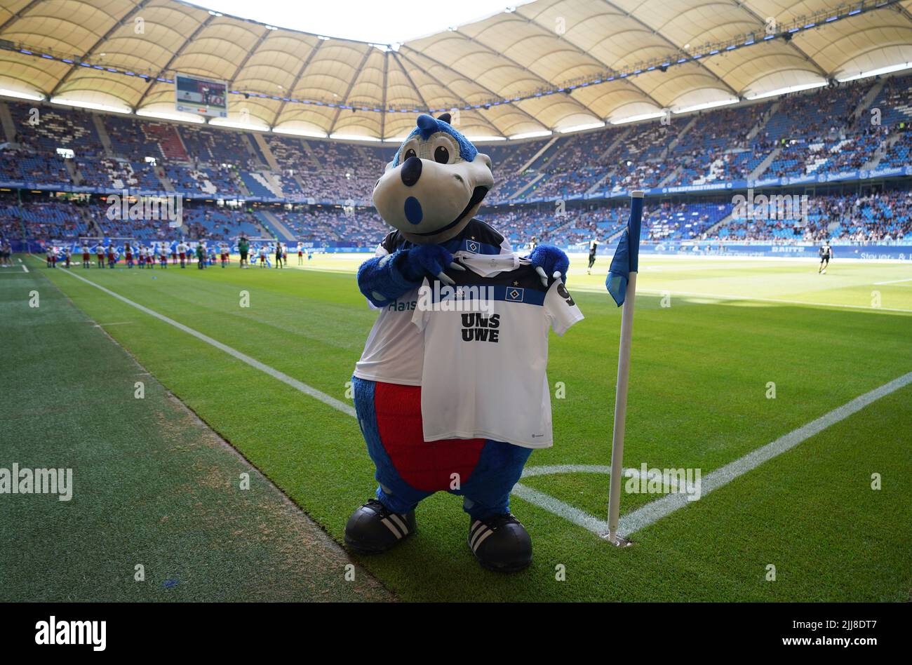 Hamburg, Germany. 24th July, 2022. Soccer: 2nd Bundesliga, Matchday 2,  Hamburger SV - Hansa Rostock, at Volksparkstadion. Hamburg's mascot "Dino  Hermann" holds up a jersey with the inscription "Uns Uwe" in memory
