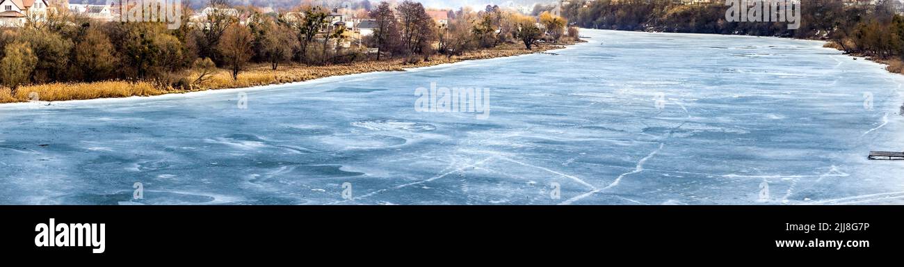 The river is covered with ice in winter. Panorama. Frozen water in the river. Beautiful landscape Stock Photo