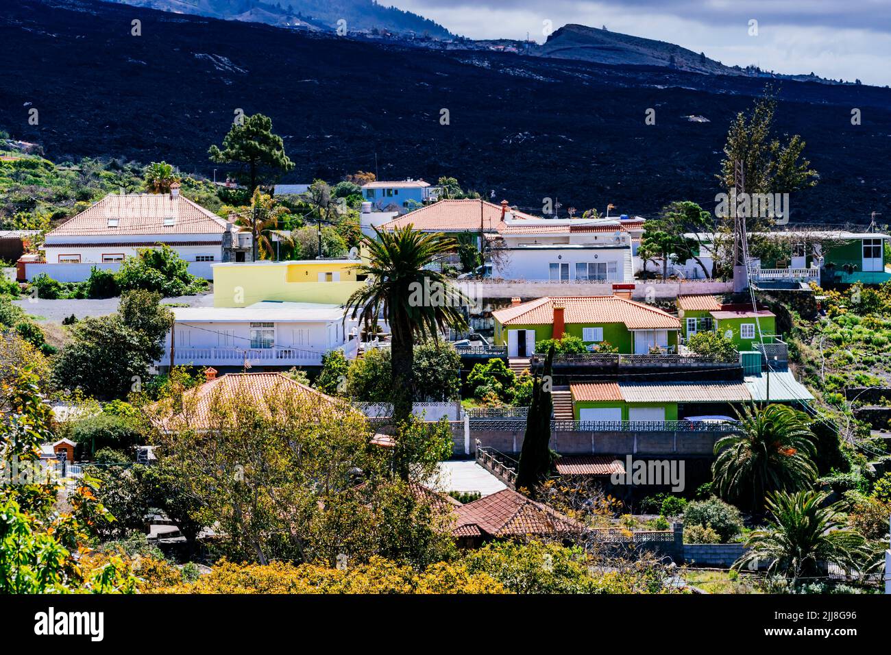 The river of solidified lava next to houses. Destruction caused by the lava river in the Aridane Valley. La Palma, Canary Islands, Spain Stock Photo