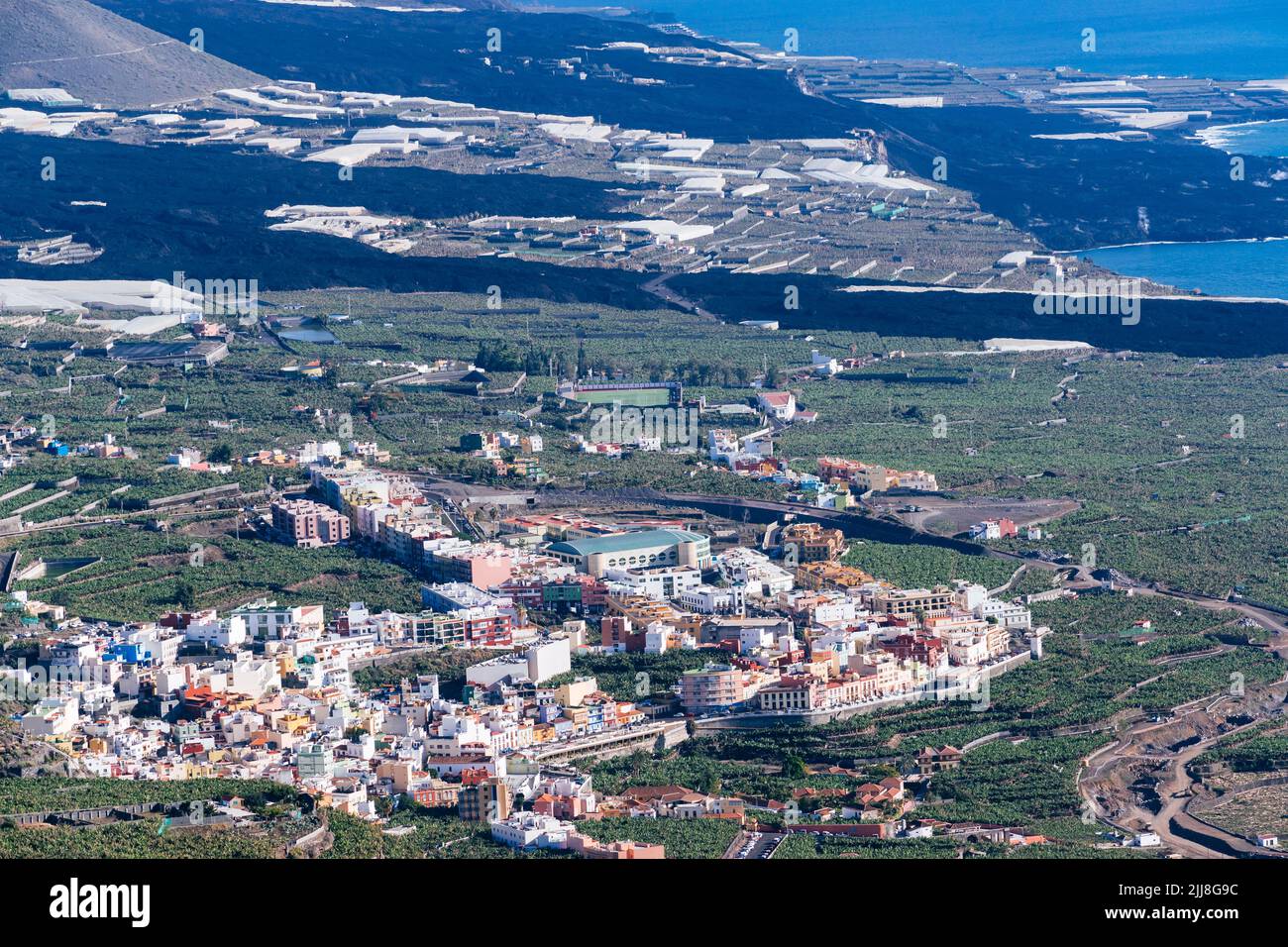 The town of Tazacorte surrounded by banana plantations. Behind the river of solidified lava that crosses the Aridane valley. La Palma, Canary Islands, Stock Photo