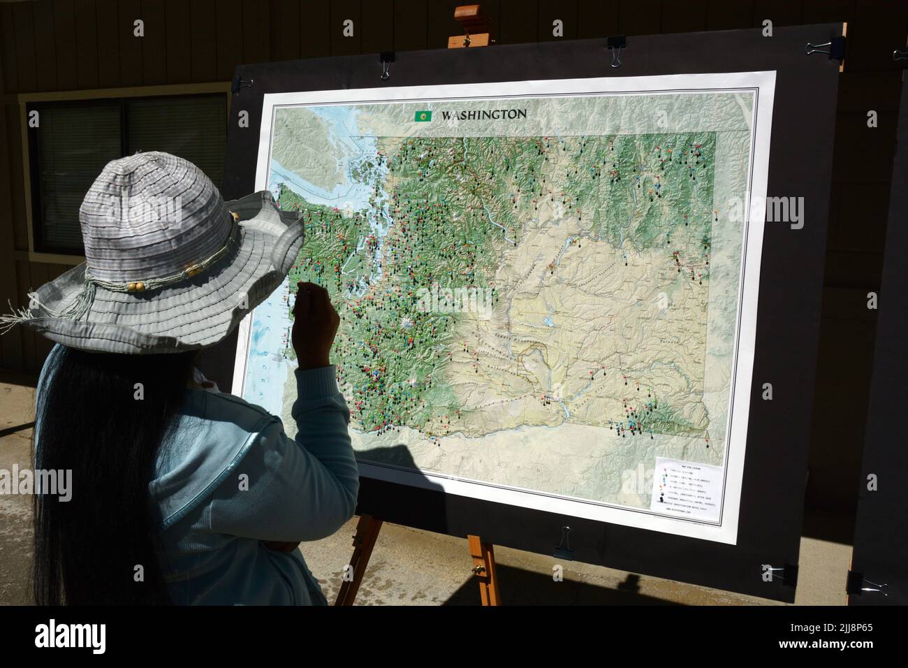 Woman looking at a map showing - Woman Looking At A Map Showing The Locations Of Sasquatch Sightings On Display At The Metaline Falls Bigfoot Festival In Washington State Usa 2JJ8P65 