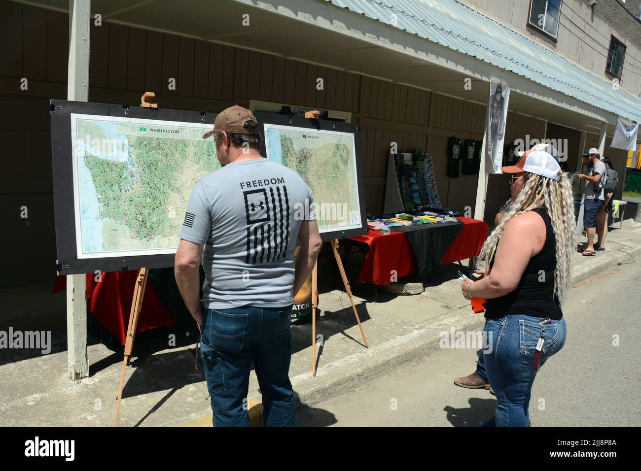 People looking at maps showing the locations of Sasquatch sightings in Washington State and Oregon, at the Metaline Falls Bigfoot Festival, WA, USA. Stock Photo