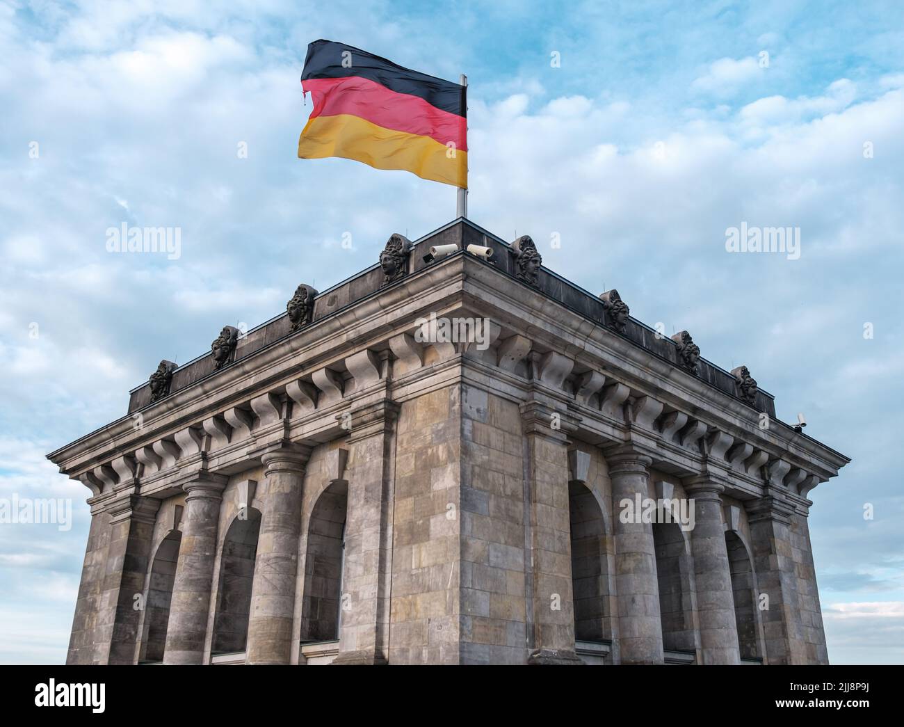 The German Flag Flying Atop The Reichstag In Berlin, Germany Stock Photo