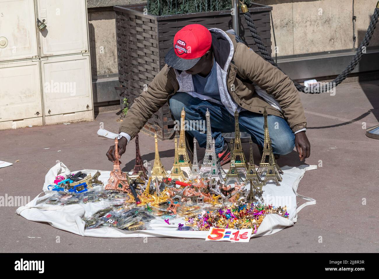 PARIS / FRANCE - JUNE 10, 2019: black man selling Eiffel tower souvenirs on the streets of Paris Stock Photo