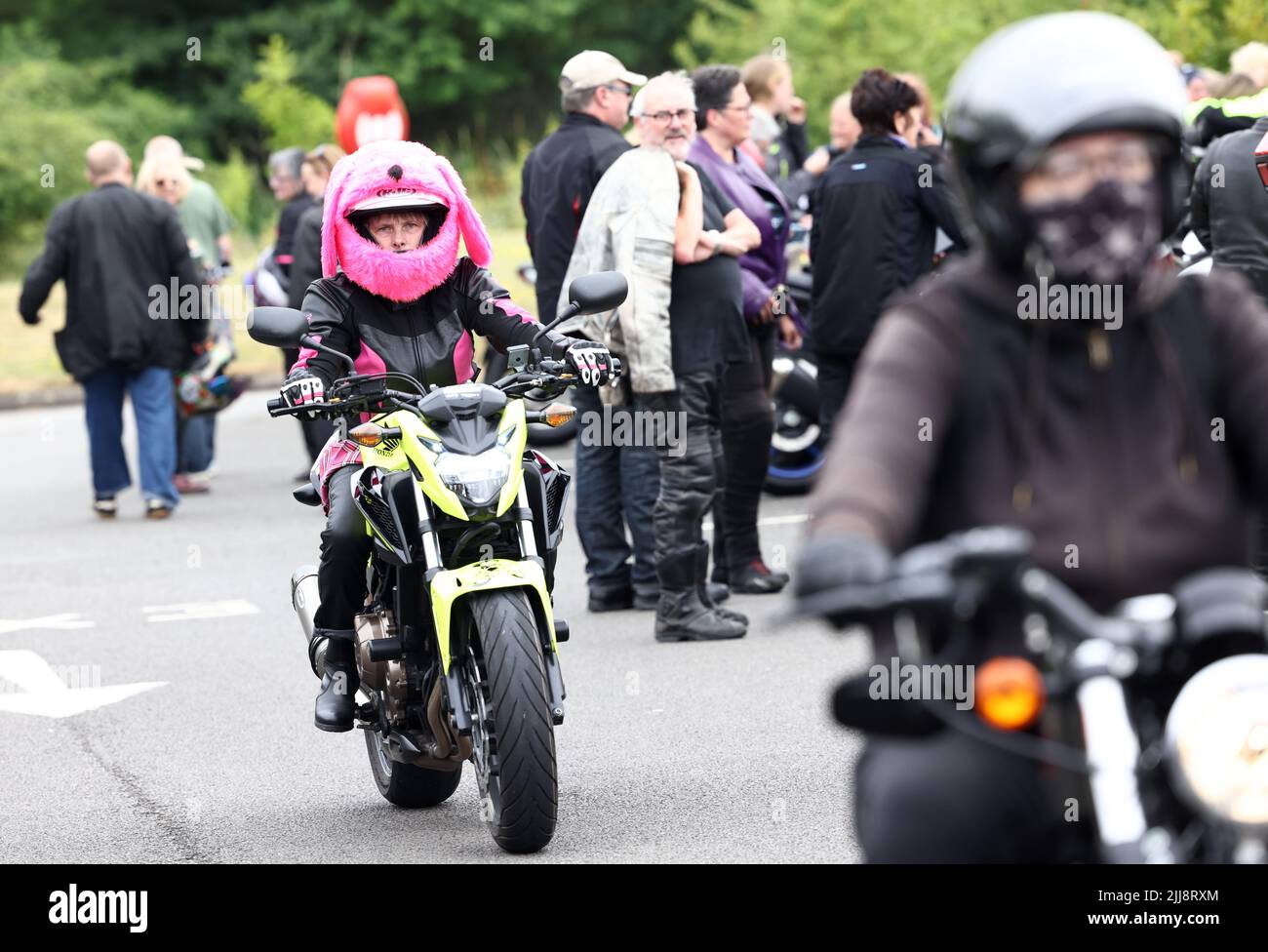 Hinckley, Leicestershire, UK. 24th July 2022. A rider in a pink fluffy bike helmet arrives during a World Record attempt for the largest Female biker meet at the global headquarters for Triumph Motorcycles. Credit Darren Staples/Alamy Live News. Stock Photo