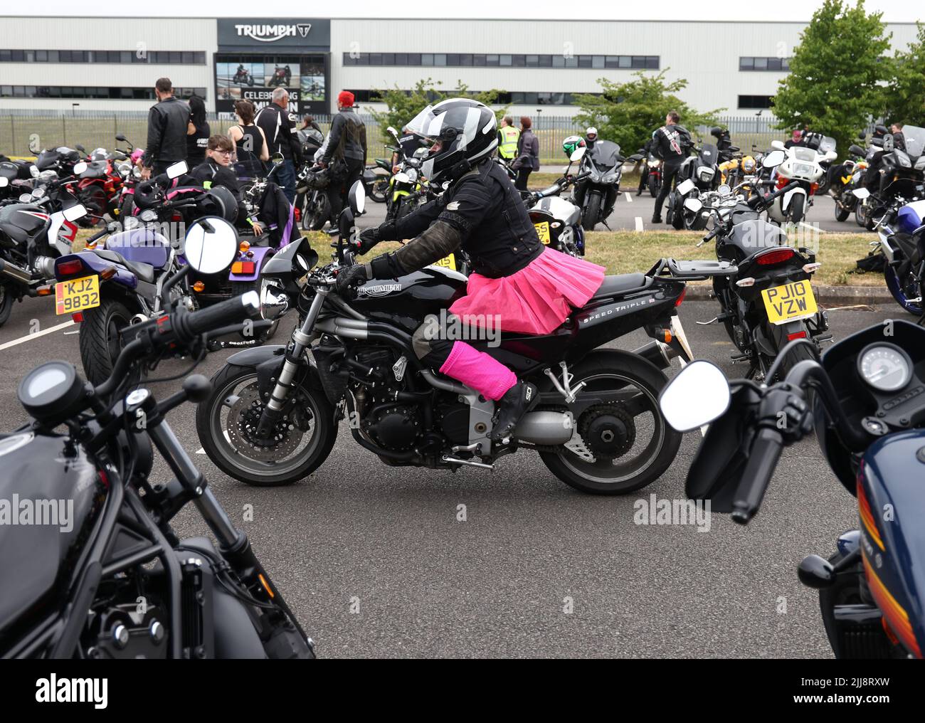 Hinckley, Leicestershire, UK. 24th July 2022. A woman dressed in a pink tutu rides between motorcycles during a World Record attempt for the largest Female biker meet at the global headquarters for Triumph Motorcycles. Credit Darren Staples/Alamy Live News. Stock Photo