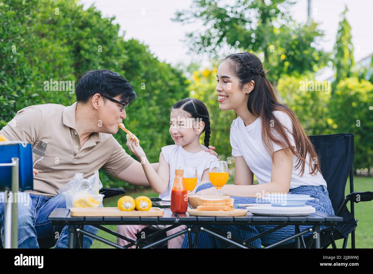 funny family outdoor party leisure activity parents with child cute lovely happy smile at backyard. Stock Photo