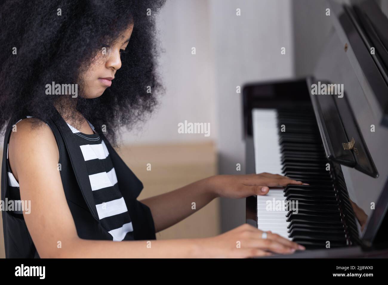 African children enjoy fun learning to play piano music instrument. Stock Photo