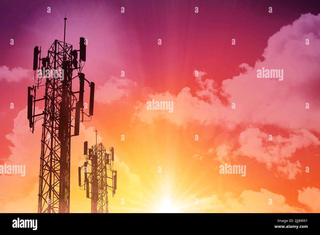 5G Communication tower or 4G network telephone cellsite silhouette on sunny colorful sky background. Stock Photo