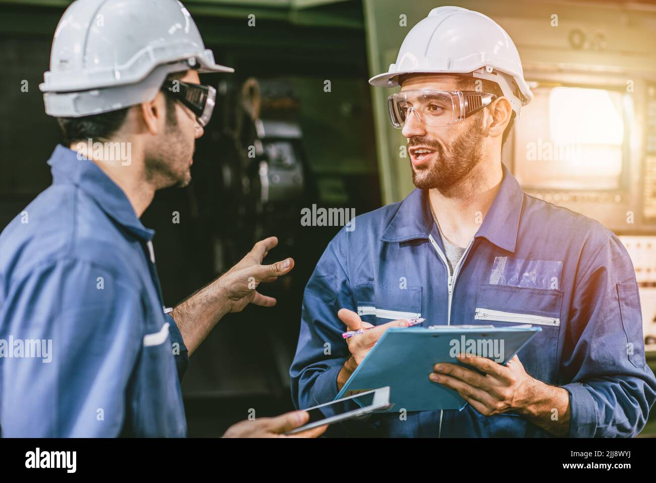 Engineer staff worker talking discussion help working team together with metal machine industry in factory. Stock Photo