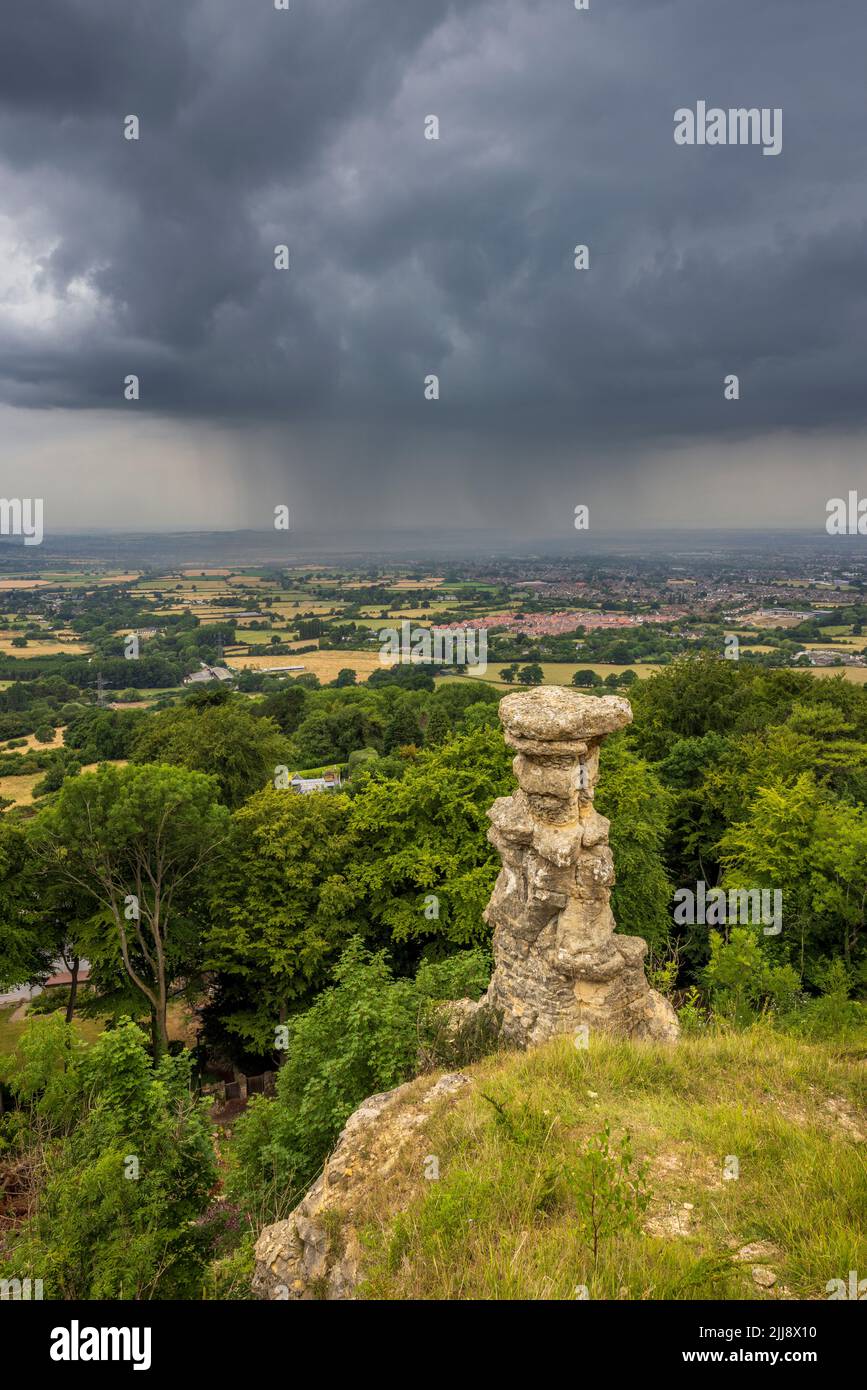 The Devil's Chimney on Leckhampton Hill with an approaching thunderstorm over Cheltenham Spa, Gloucestershire, England Stock Photo