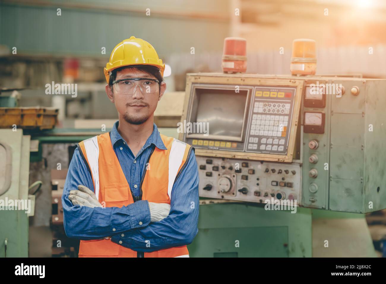 Steel factory staff worker portrait Asian man work in a heavy industrial machine with safety engineer uniform. Stock Photo