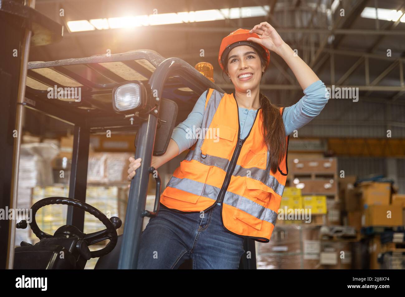 Happy woman worker warehouse staff forklift driver happy smiling enjoy working Asian people. Stock Photo