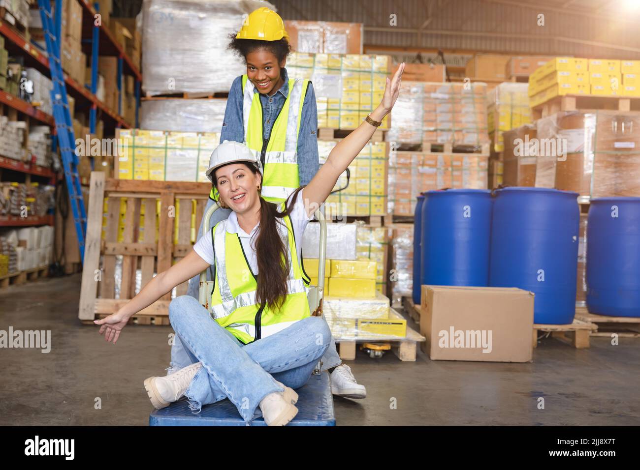 Women warehouse employee worker enjoy working teamwork with friend happy smile at workplace. Stock Photo