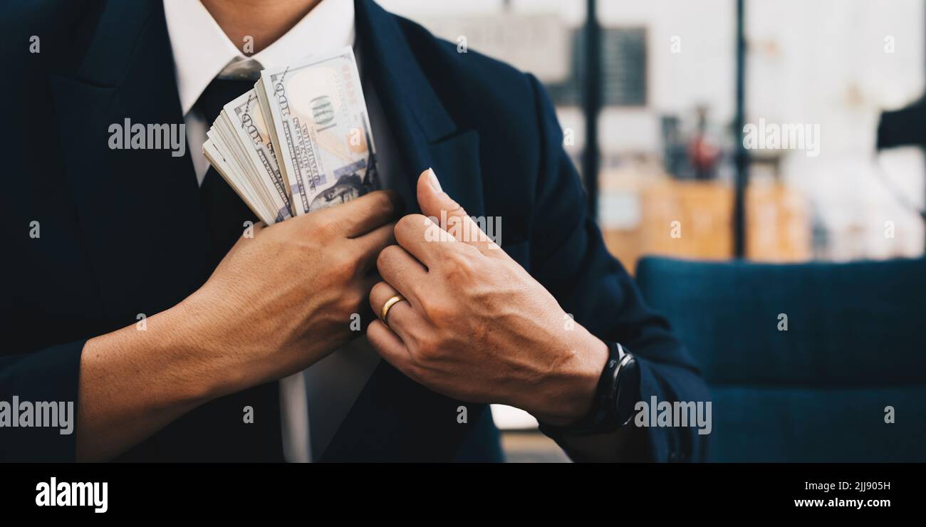 Bribed man putting money in the suit pocket. Corruption and Anti Bribery concepts. Stock Photo