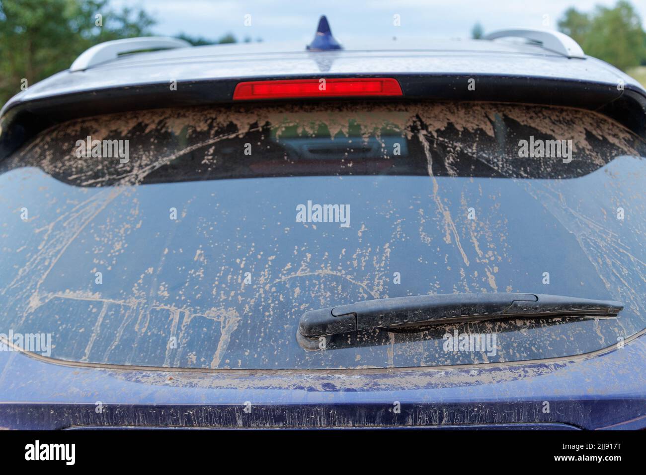 Dirty car glass with wiper and third brake light, rear window covered