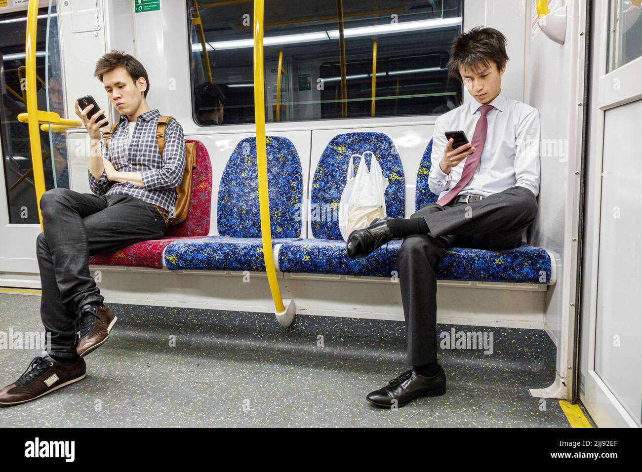 Sydney Australia,City Circle railway train onboard riders passengers rider Asian man men looking at smartphone checking reading texting commuters Stock Photo