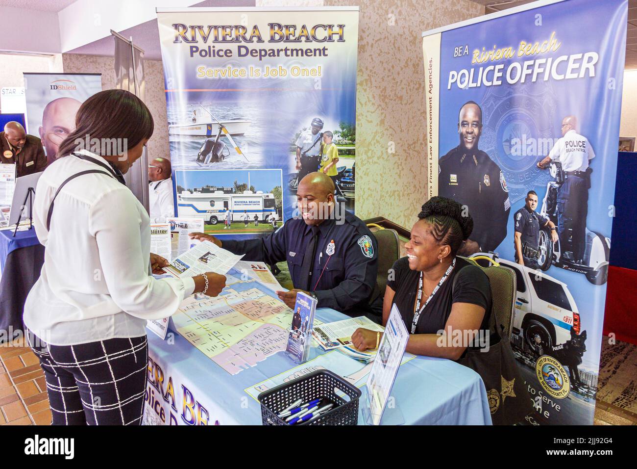 Miami Florida,National Preventing Crime in the Black Community Conference exhibitor job fair Police Department recruiter male female policeman officer Stock Photo