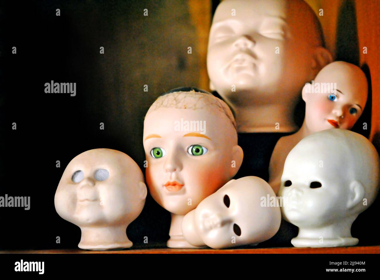 Collection of doll heads waiting for new bodies Stock Photo