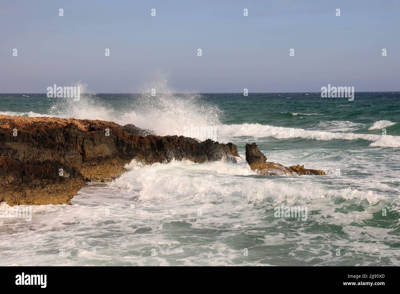 The waves of the sea crash against the rocky coast Stock Photo - Alamy