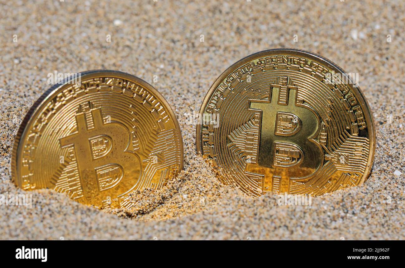 two large golden coins with the capital letter B symbolizing the cryptocurrency  BITCOIN in the middle of the gravel Stock Photo - Alamy