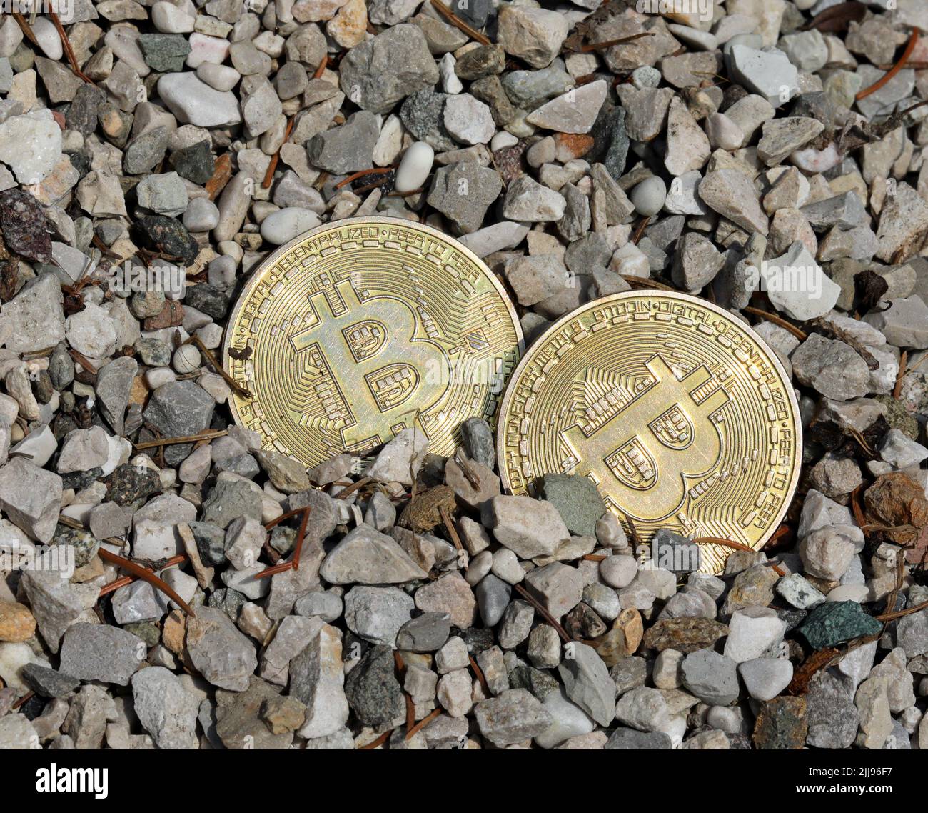 two large golden coins with the capital letter B symbolizing the  cryptocurrency BITCOIN in the middle of the gravel Stock Photo - Alamy