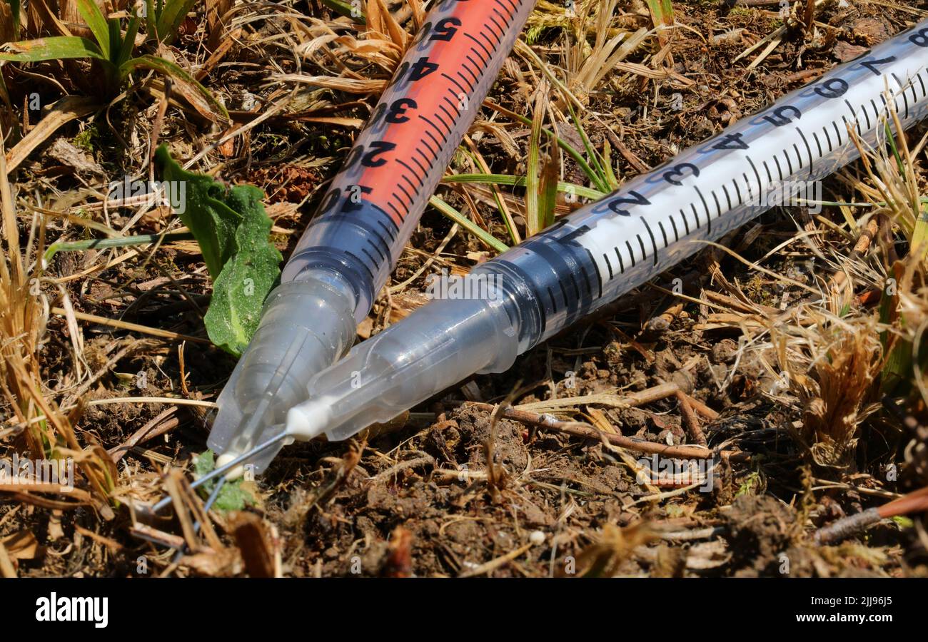 two abandoned syringes used by drug addicts left on the ground on the