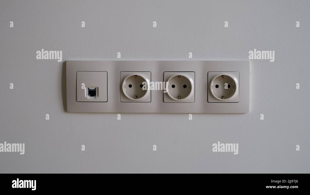 Electric socket on white wall closeup. Sockets with antenna cable and