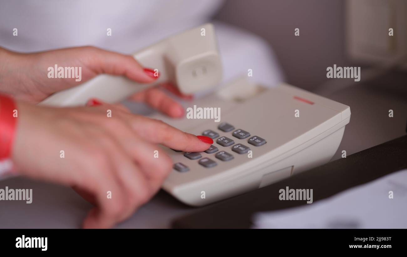 Business woman dialing phone number in hotel room Stock Photo