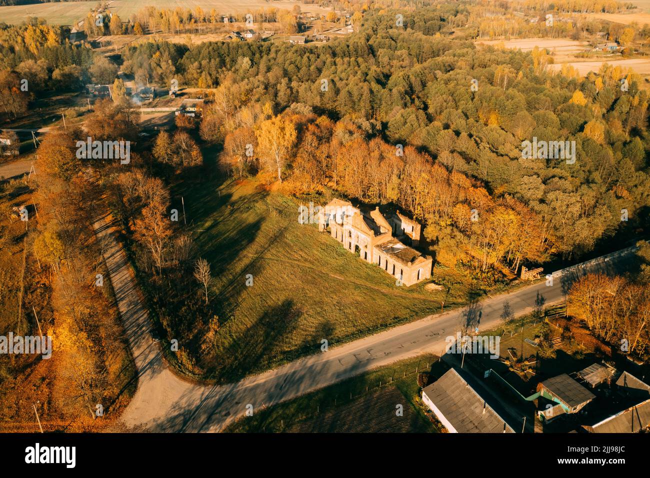 Aerial view small town in autumn landscape. Bird's-eye view of ruins of the brewery, neo-gothic monument of industrial architecture of the early 20th Stock Photo