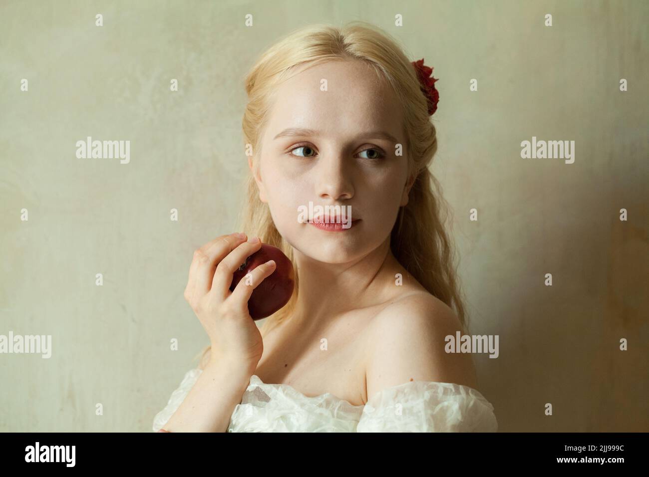 Portrait of cute blonde woman with red apple Stock Photo
