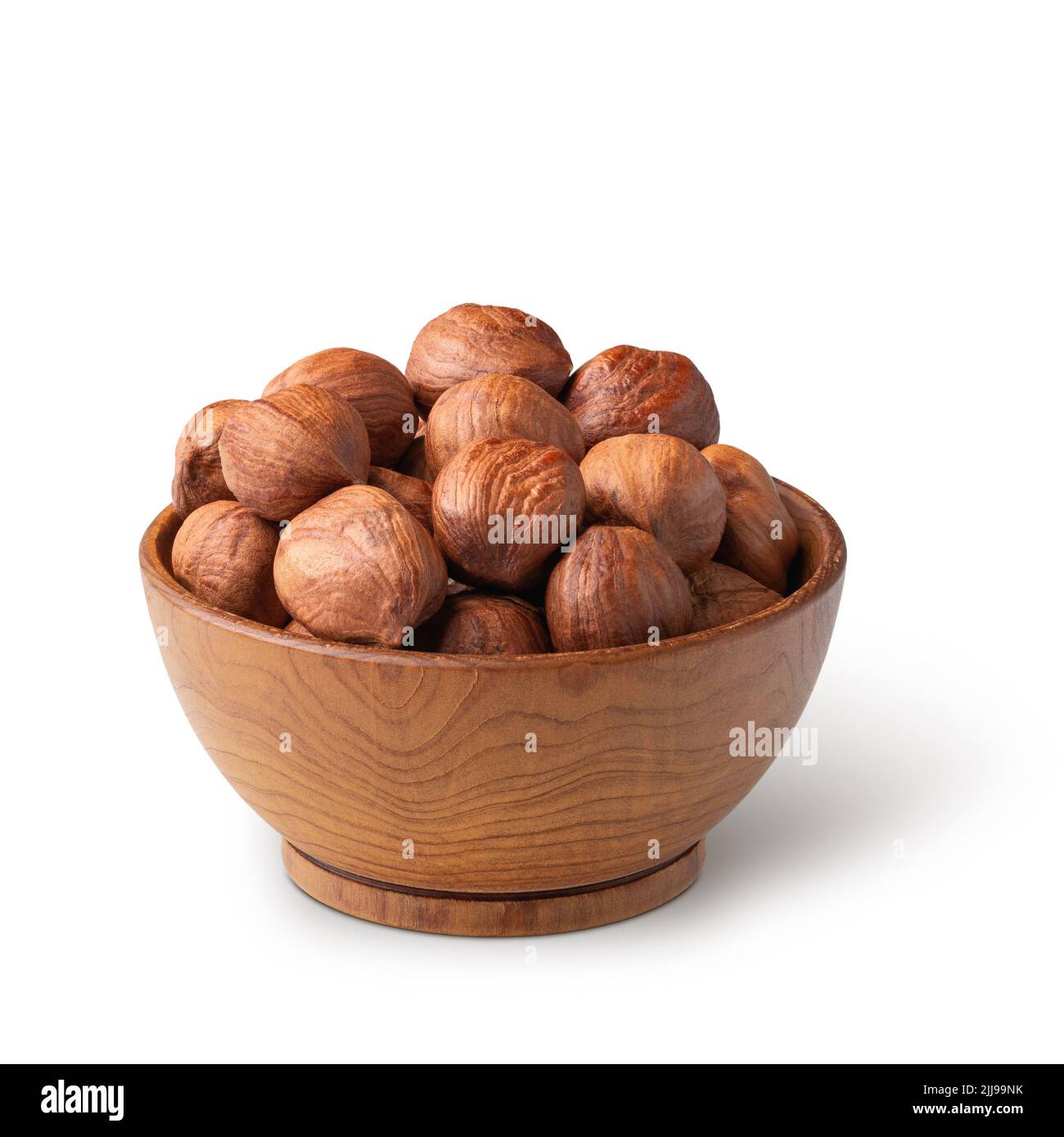 Wooden bowl full of hazelnuts isolated on white. Deep focus Stock Photo