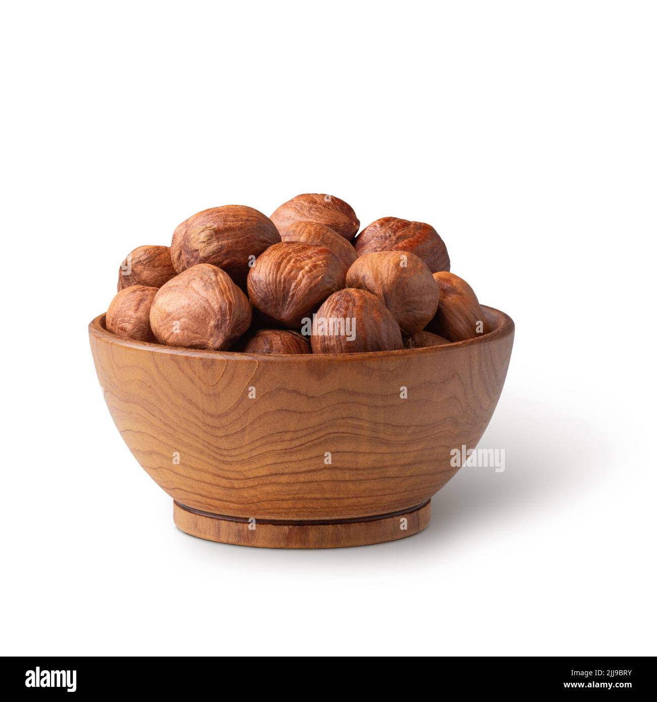 Wooden bowl full of hazelnuts isolated on white. Deep focus Stock Photo