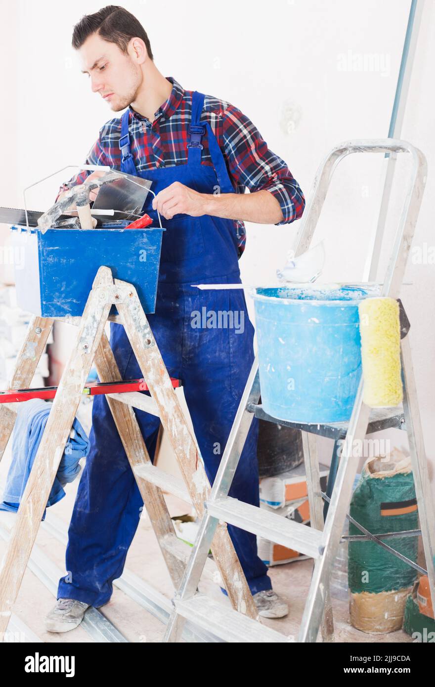 Worker looking for necessary tool in toolbox Stock Photo