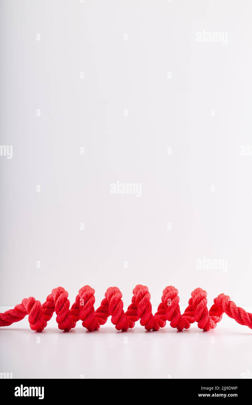 Red rope with a spiral Isolated on white background. Red colorful lasso with a spiral on the white table. Stock Photo