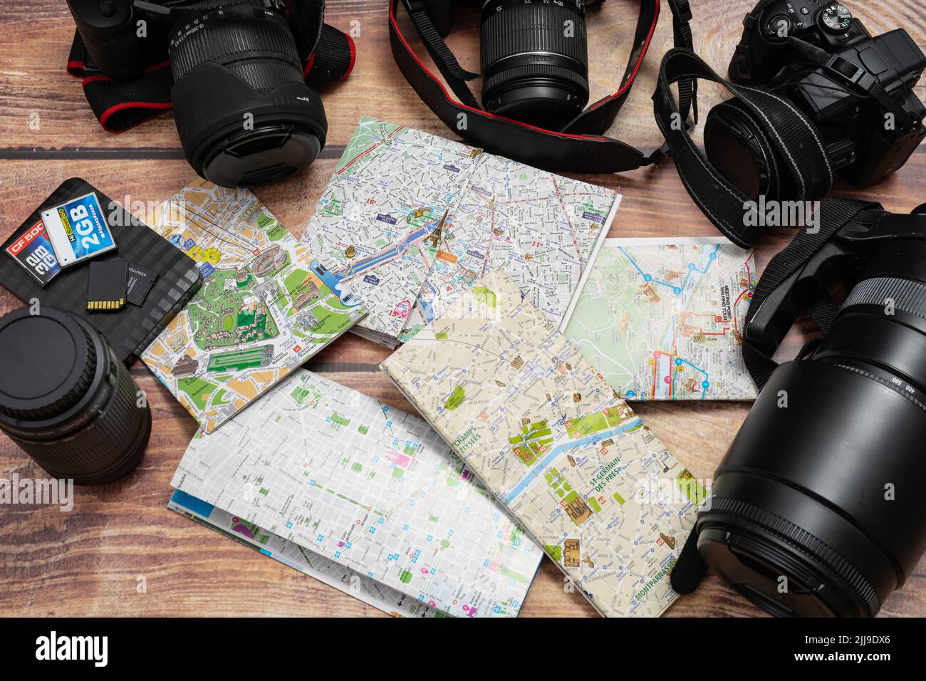 City maps next to cameras and passport on a wooden table. Concept of vacations, travels, travelers, Copy space. Stock Photo