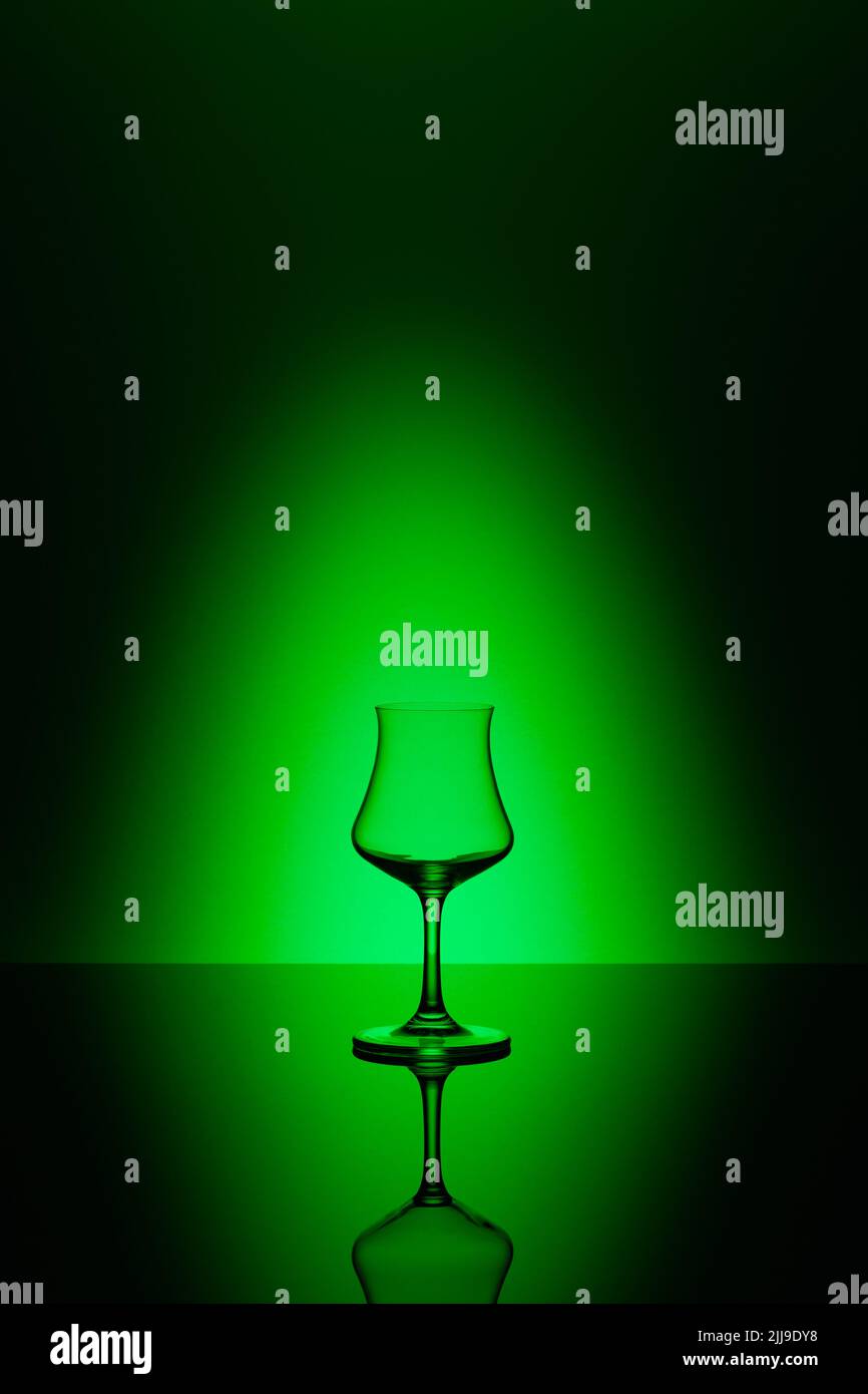 Rum tasting glass on the glass table and green background Stock Photo