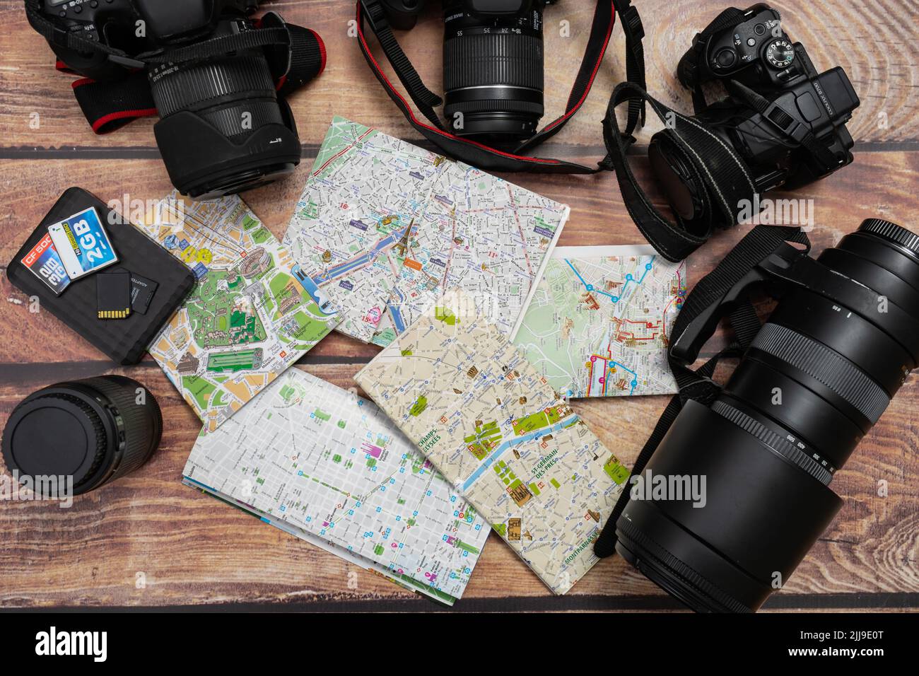 City maps next to cameras and passport on a wooden table. Concept of vacations, travels, travelers, Copy space. Stock Photo