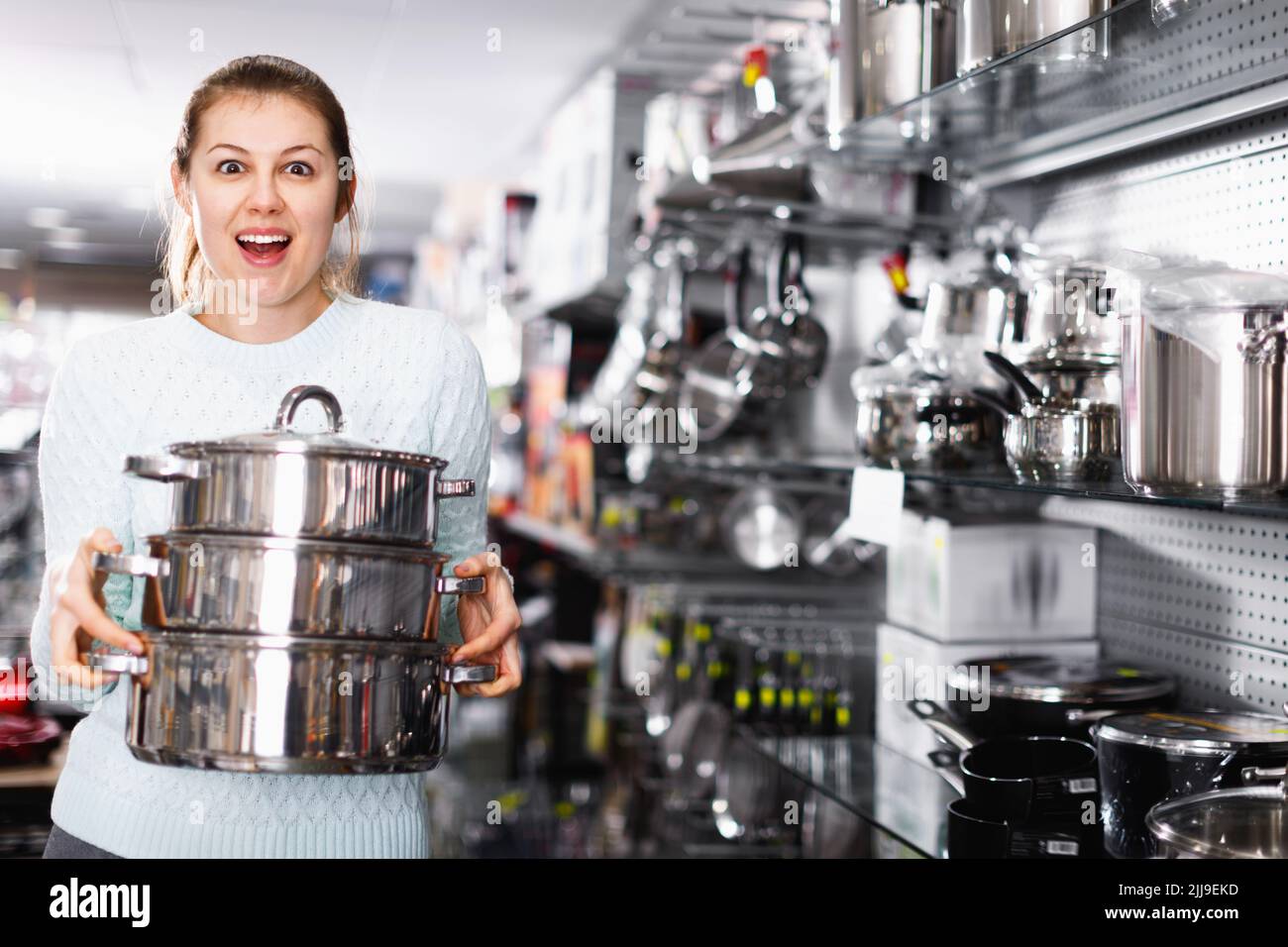 Woman is choosing saucepan for her house in the store Stock Photo Alamy