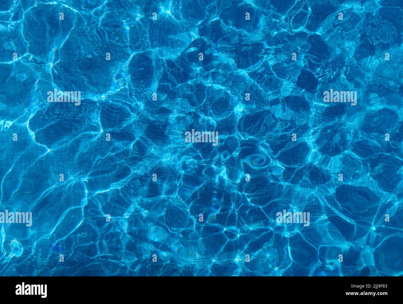 Perfect background shot for designers of beautiful blue colored swimming pool water with a pattern of squares in the background Stock Photo